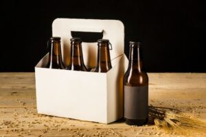 Cervezas en caja de cartón y espigas de trigo